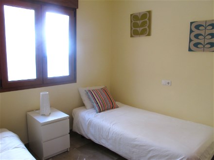 The second bedroom has two single beds